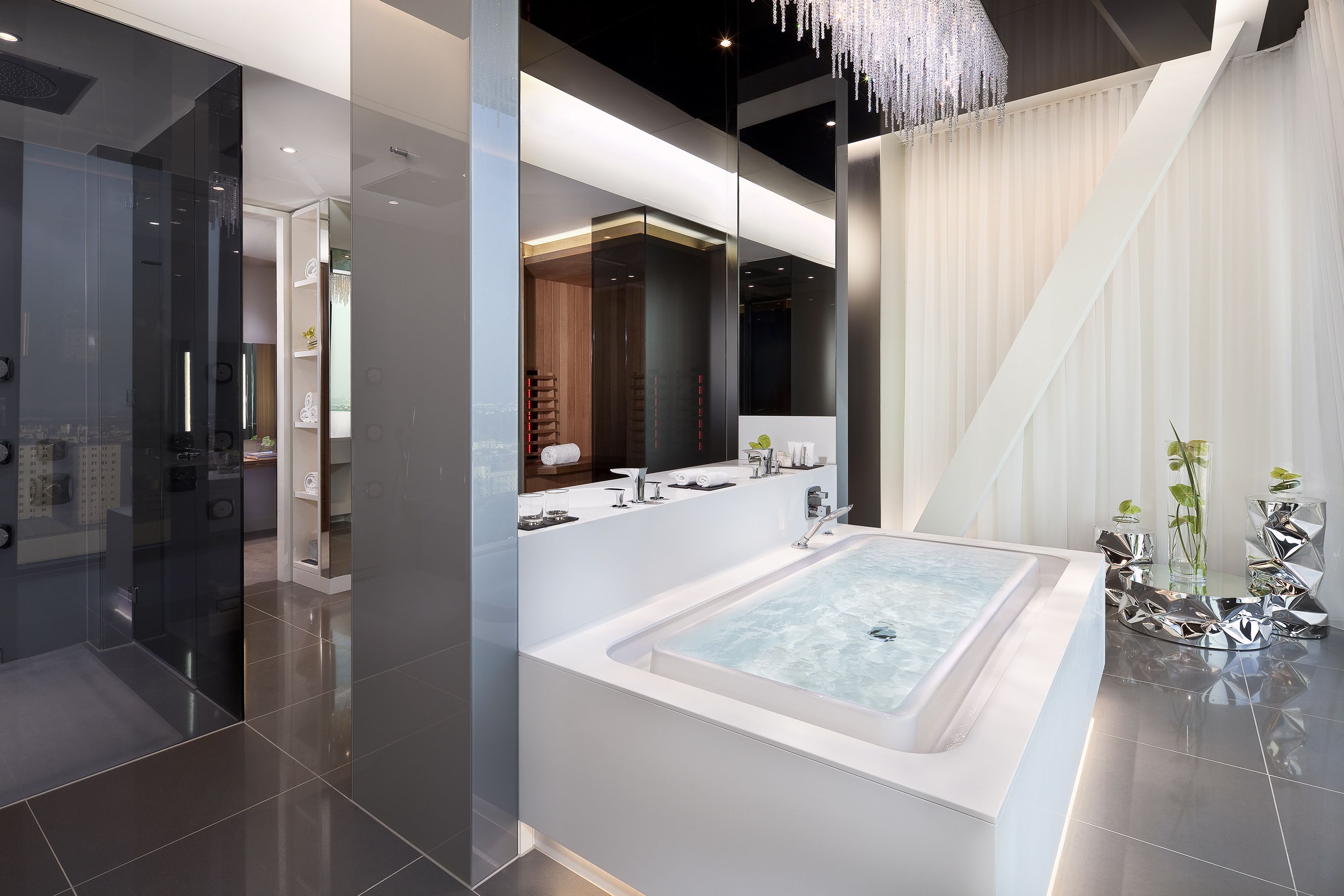 Modern luxury bathroom with white built-in tub, glass shower, and sleek design.