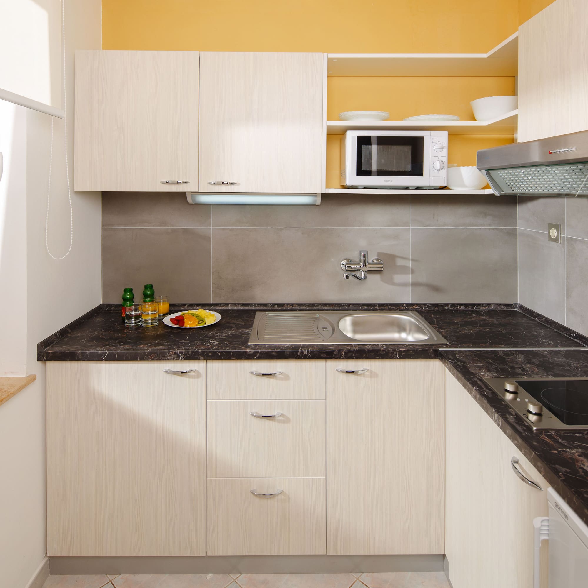 a kitchen with white cabinets and black counter tops