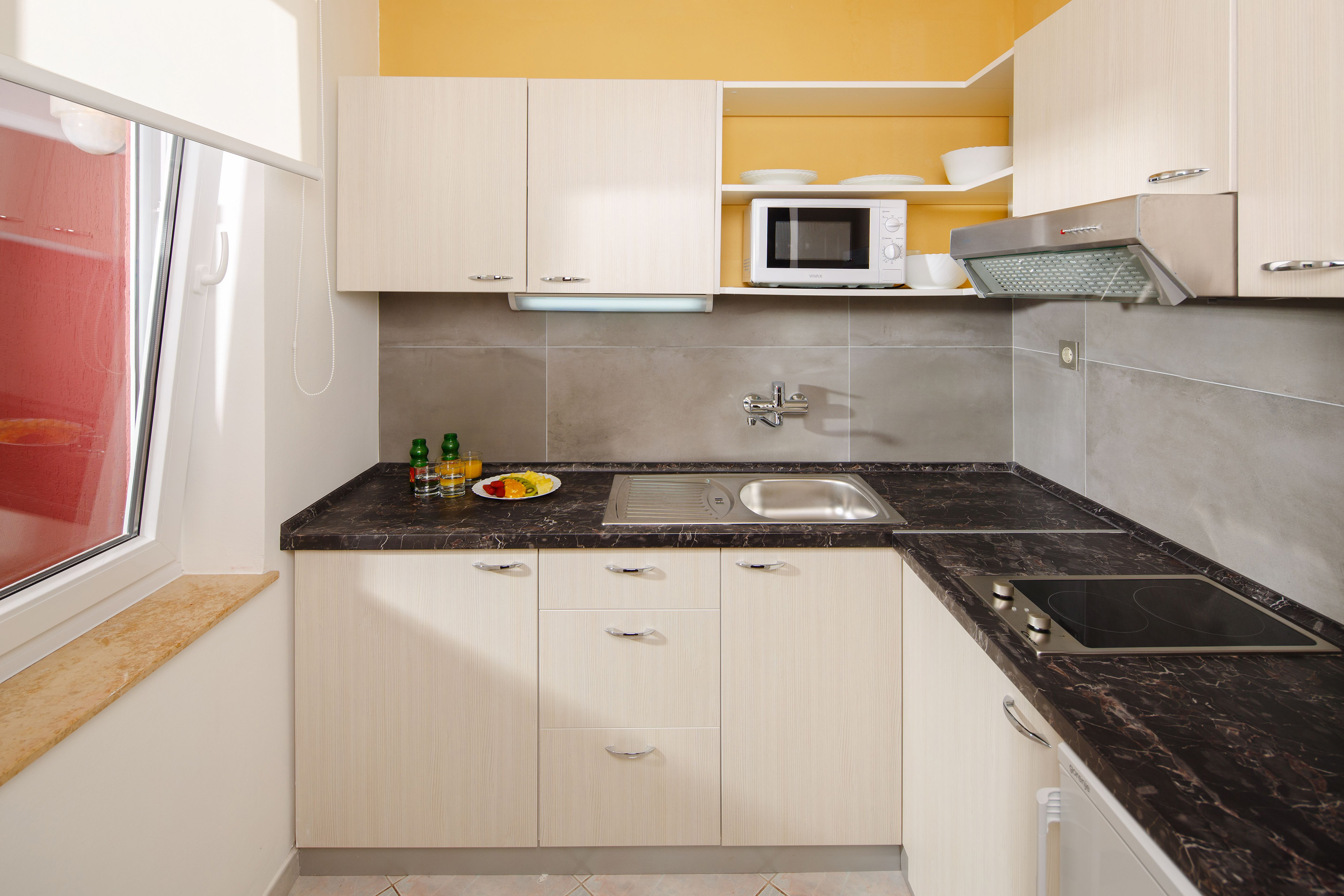 a kitchen with white cabinets and black counter tops