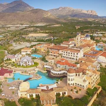 a large building with a pool and a large building with a large mountain in the background