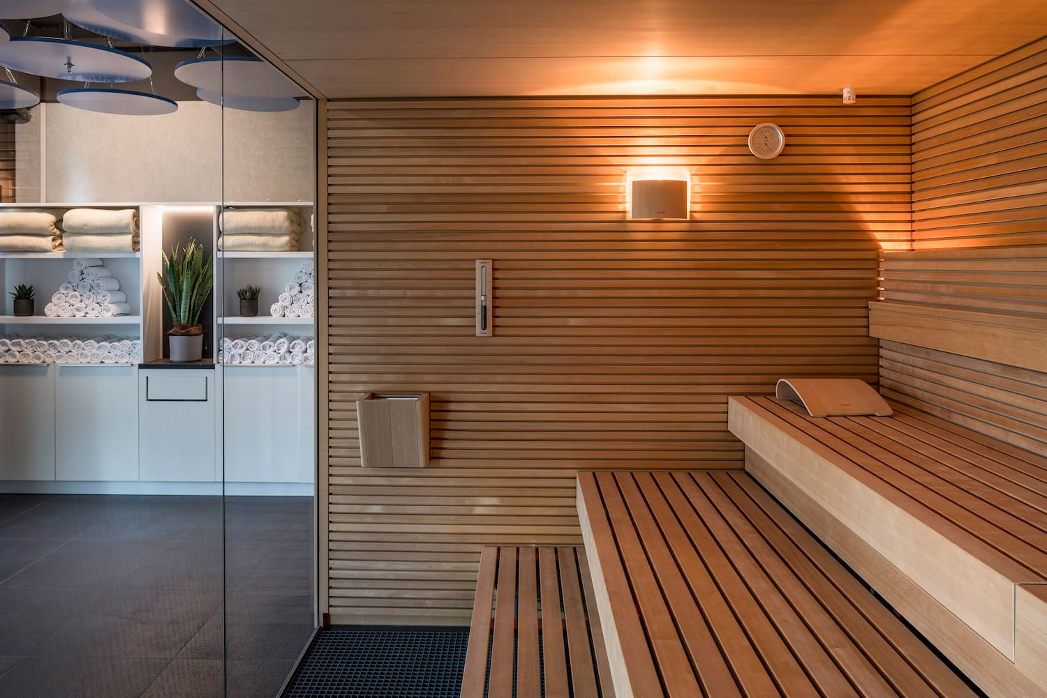 a sauna with wood walls and a glass door