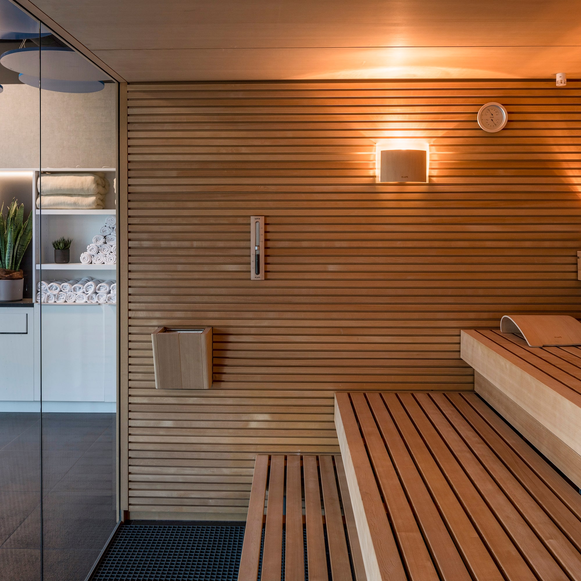 a sauna with wood walls and a glass door