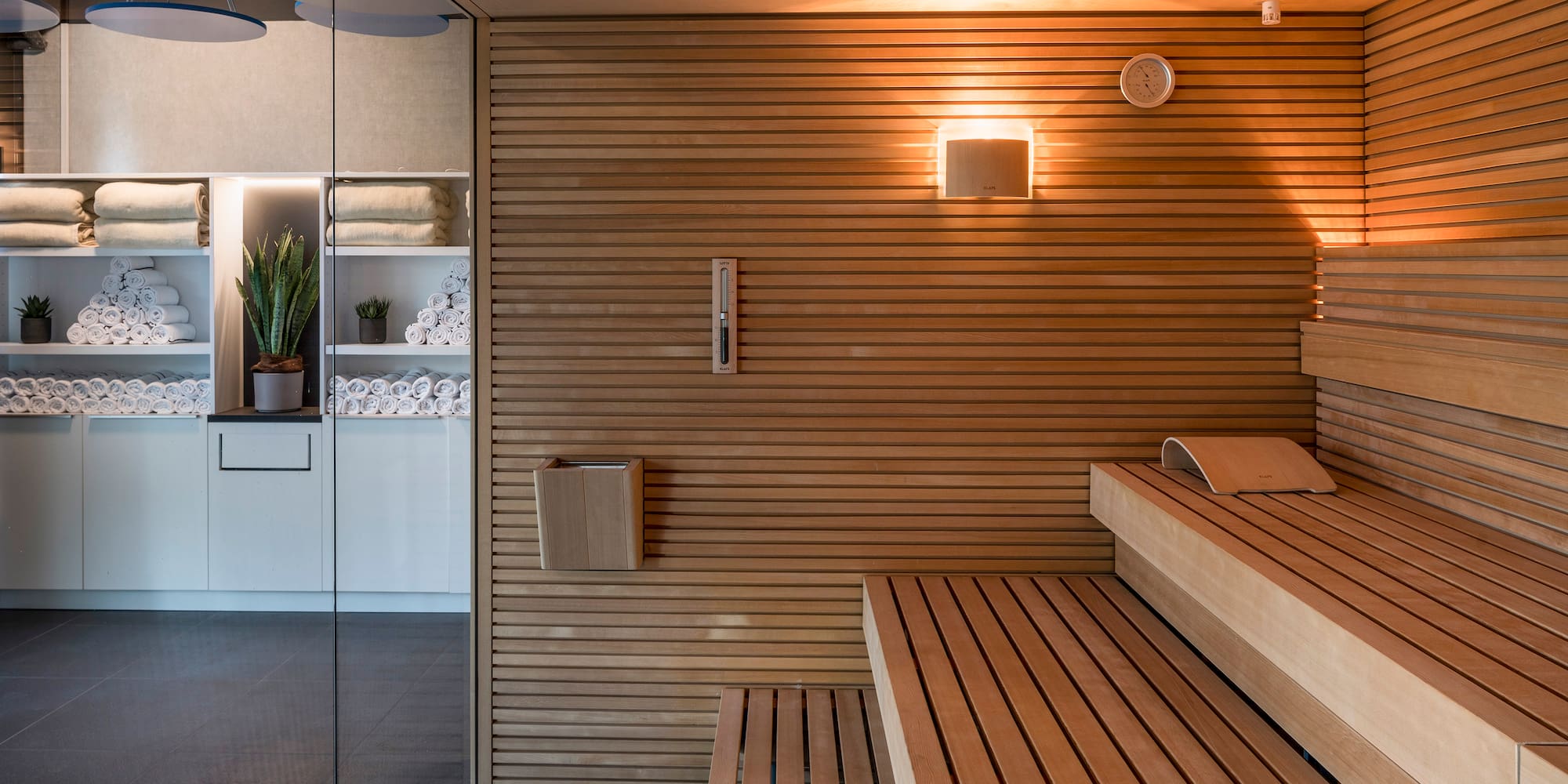 a sauna with wood walls and a glass door