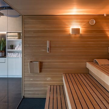 a sauna with wood walls and a glass door
