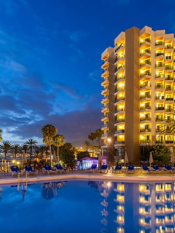 a building with lights on the outside of a pool