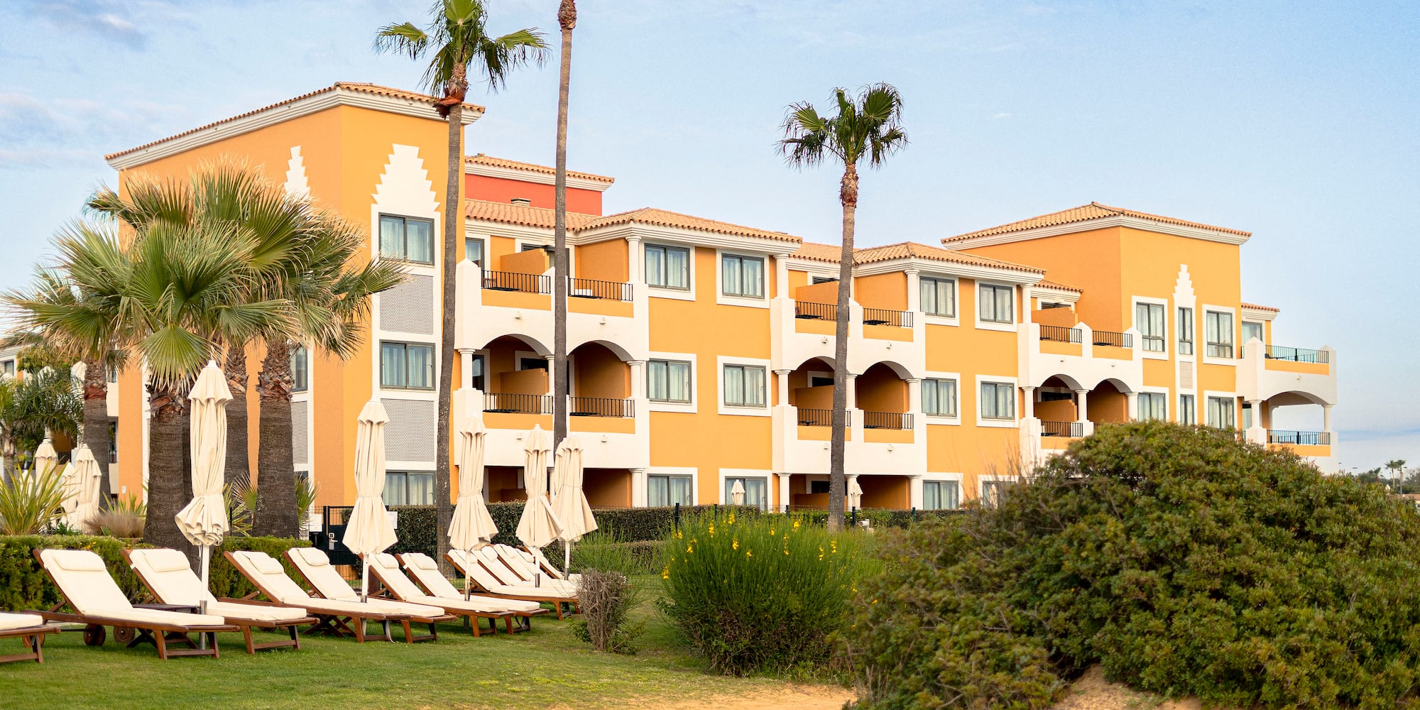 a hotel with palm trees and chairs