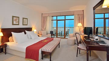 a room with a bed and chairs and a table