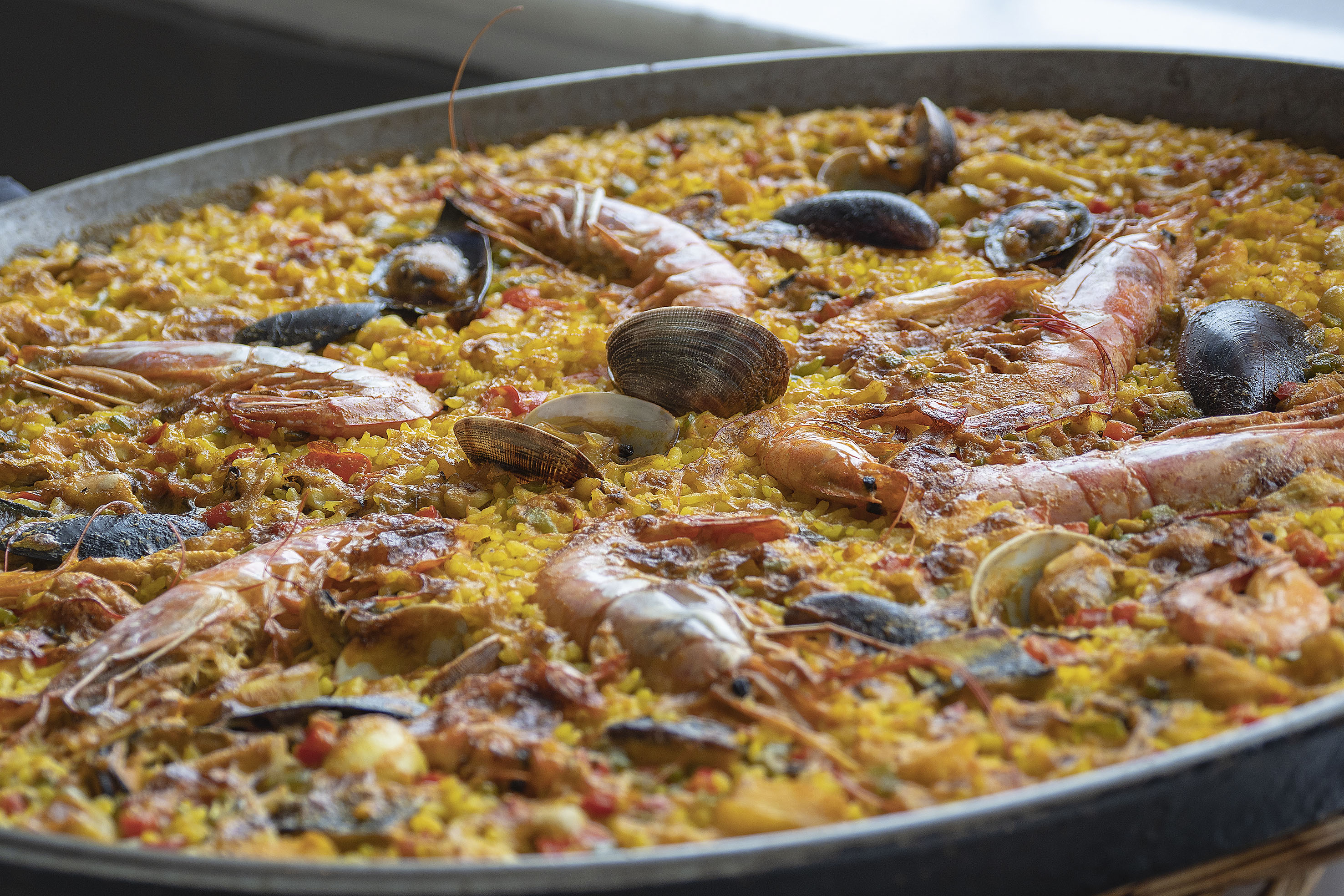 Seafood paella with yellow rice, shrimp, mussels, and clams.