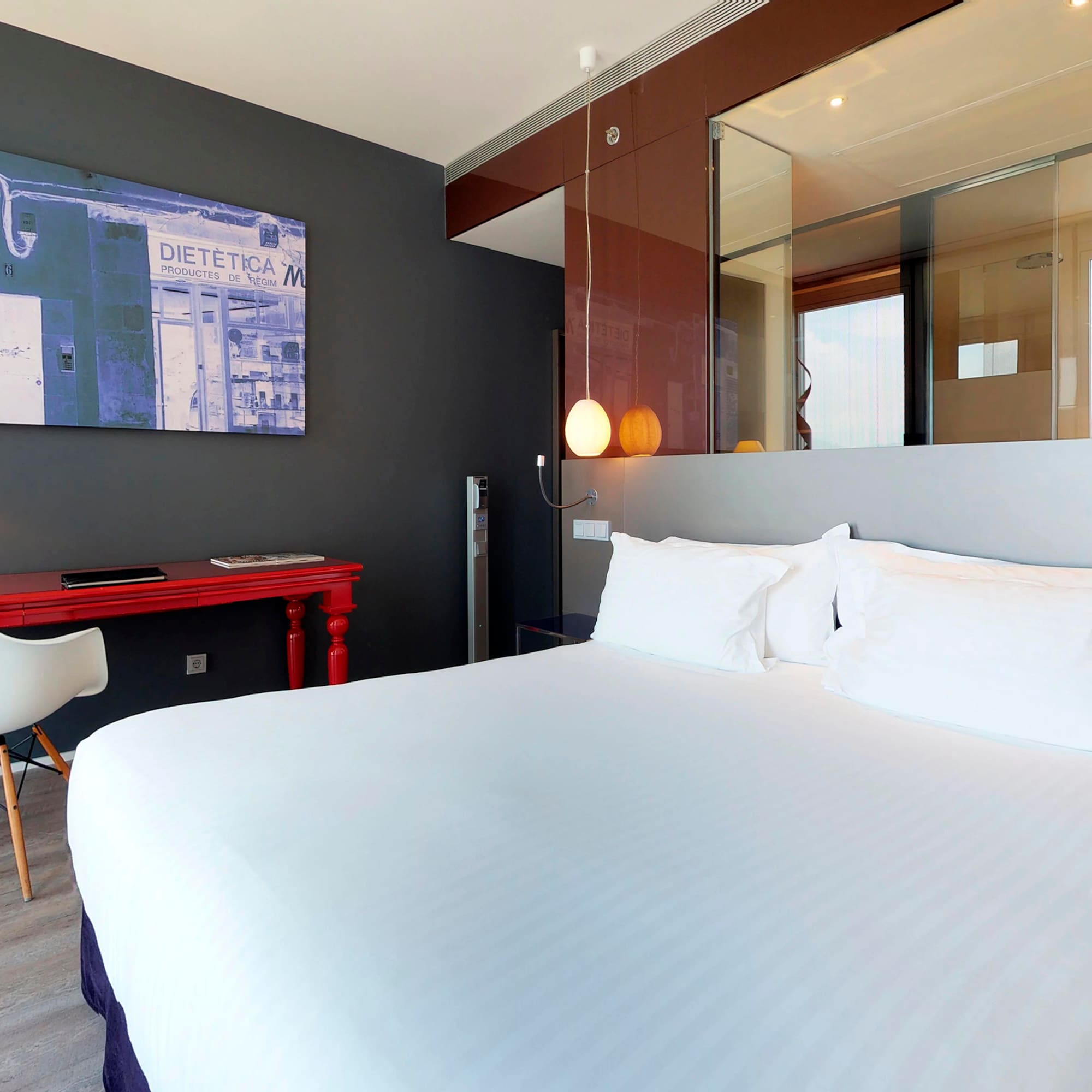 a bed with white sheets and a desk in a room