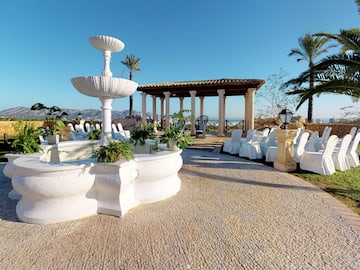 a white fountain with chairs and a gazebo