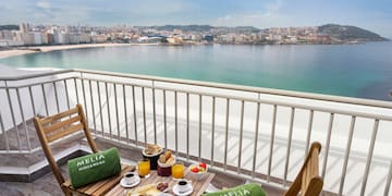 a table with food and drinks on a balcony overlooking a city