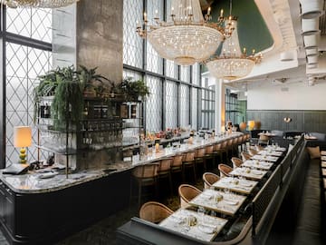 a long table with chairs and chandeliers