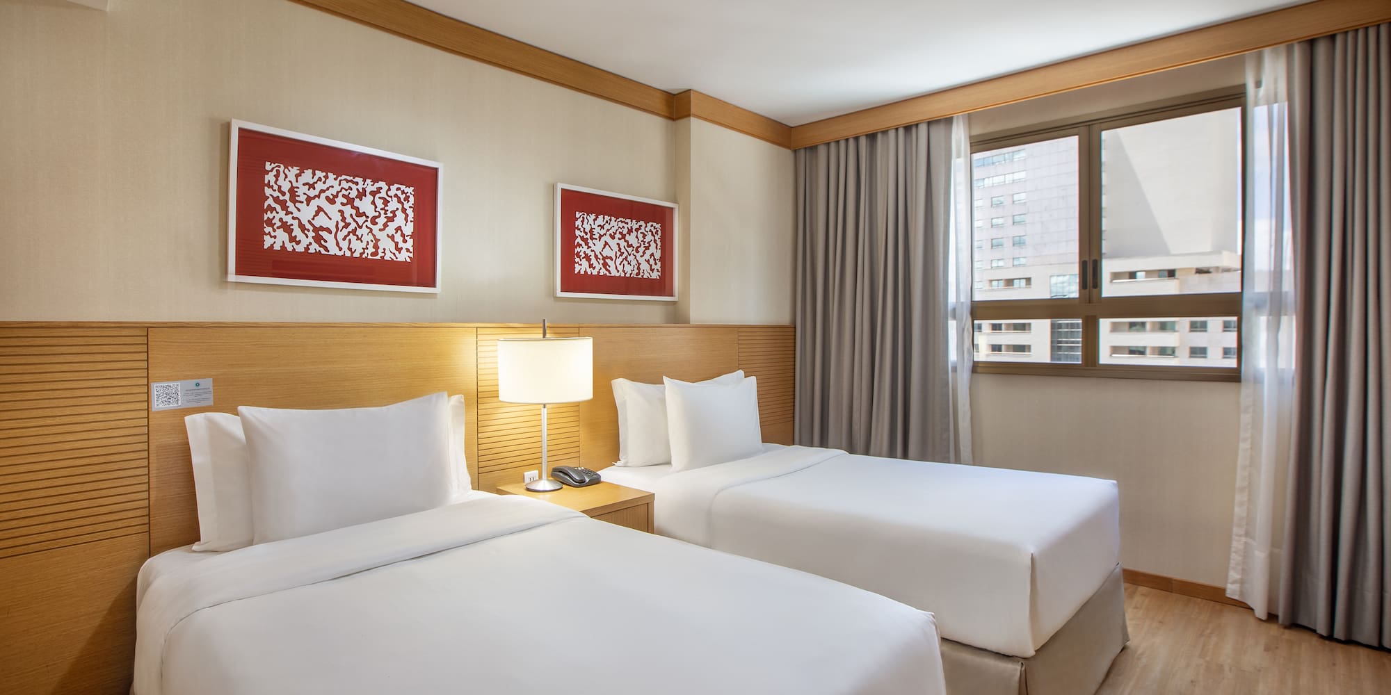 a room with two beds and a lamp