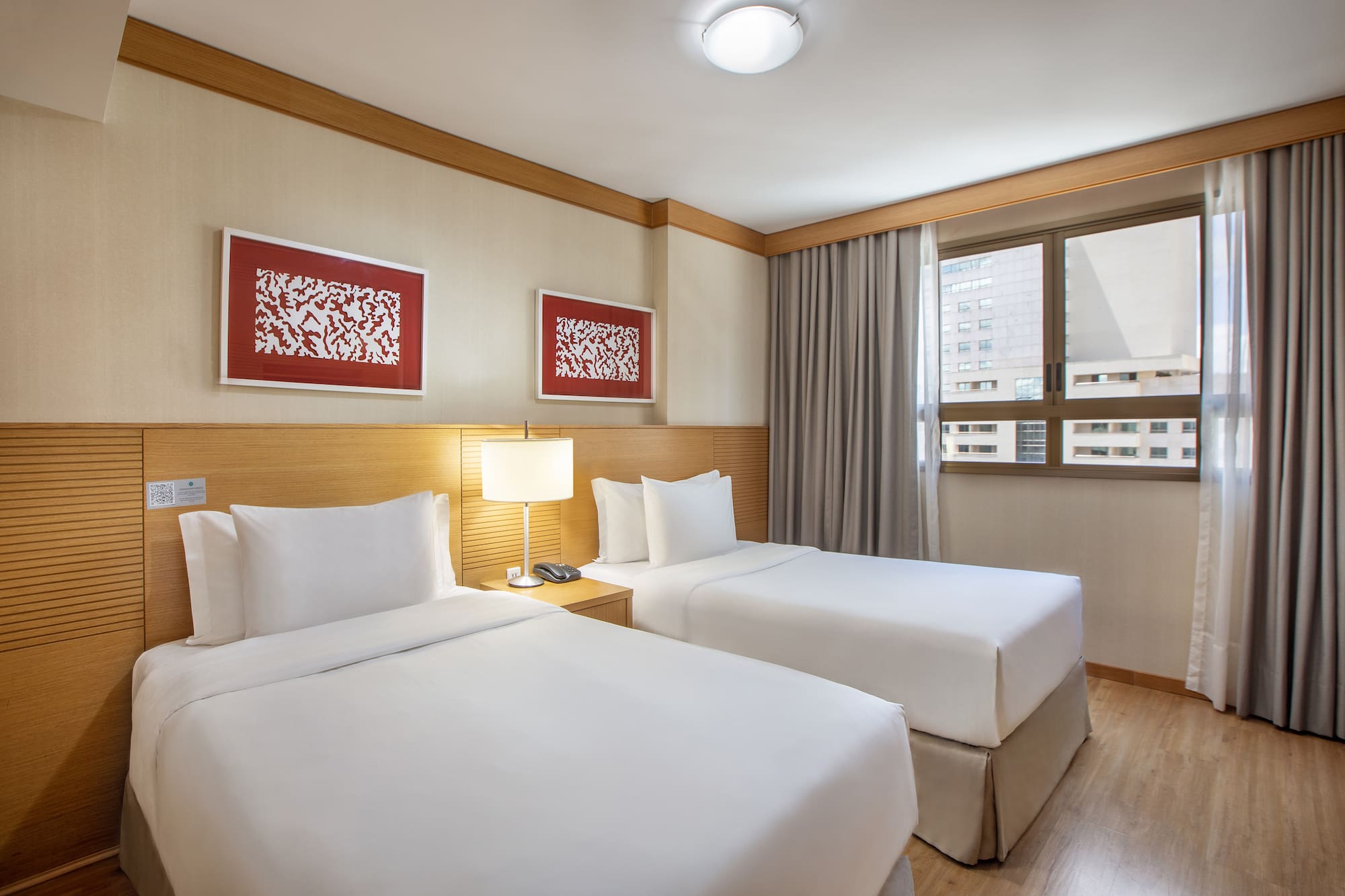 a room with two beds and a lamp