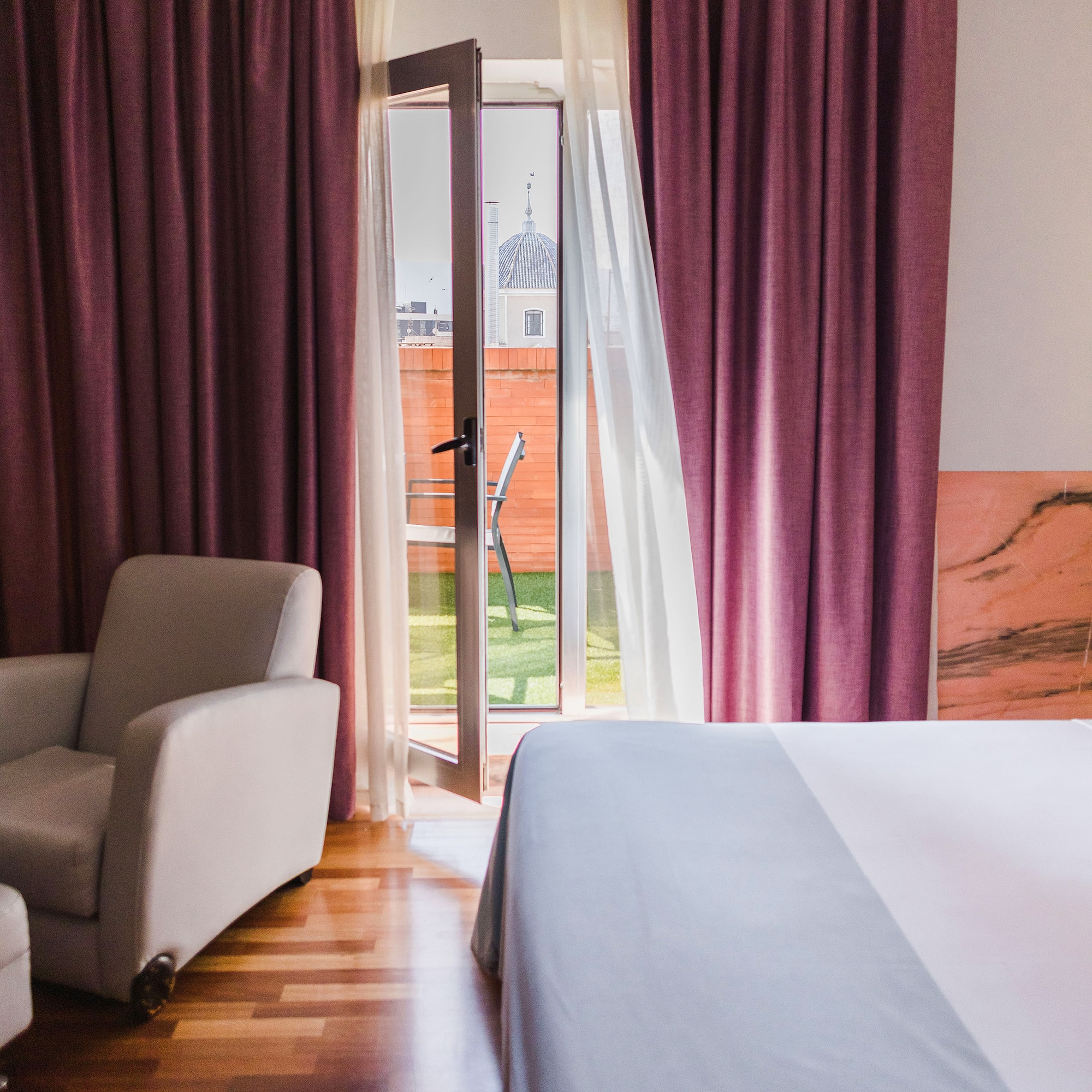 a bedroom with a bed and chairs and a door