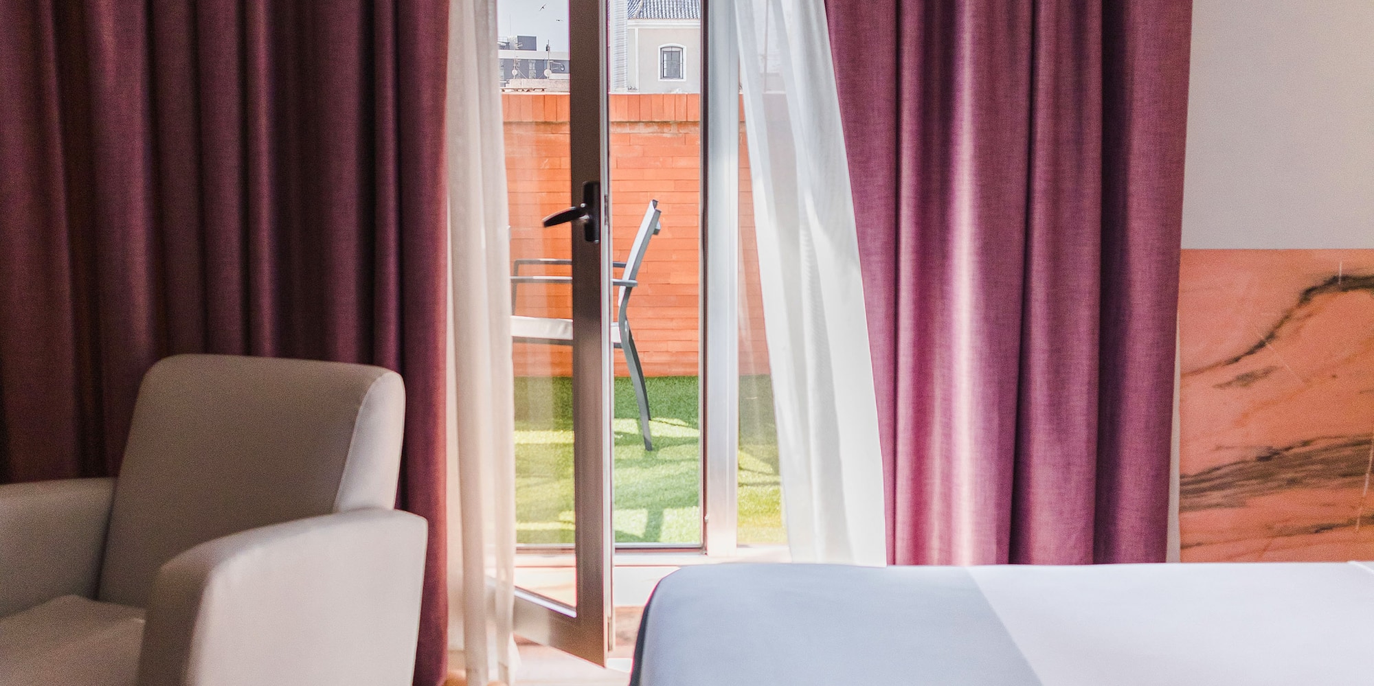 a bedroom with a bed and chairs and a door