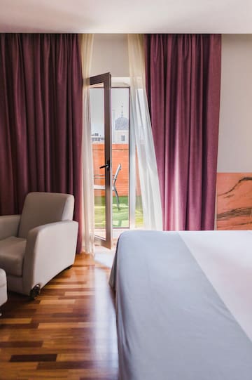 a bedroom with a bed and chairs and a door