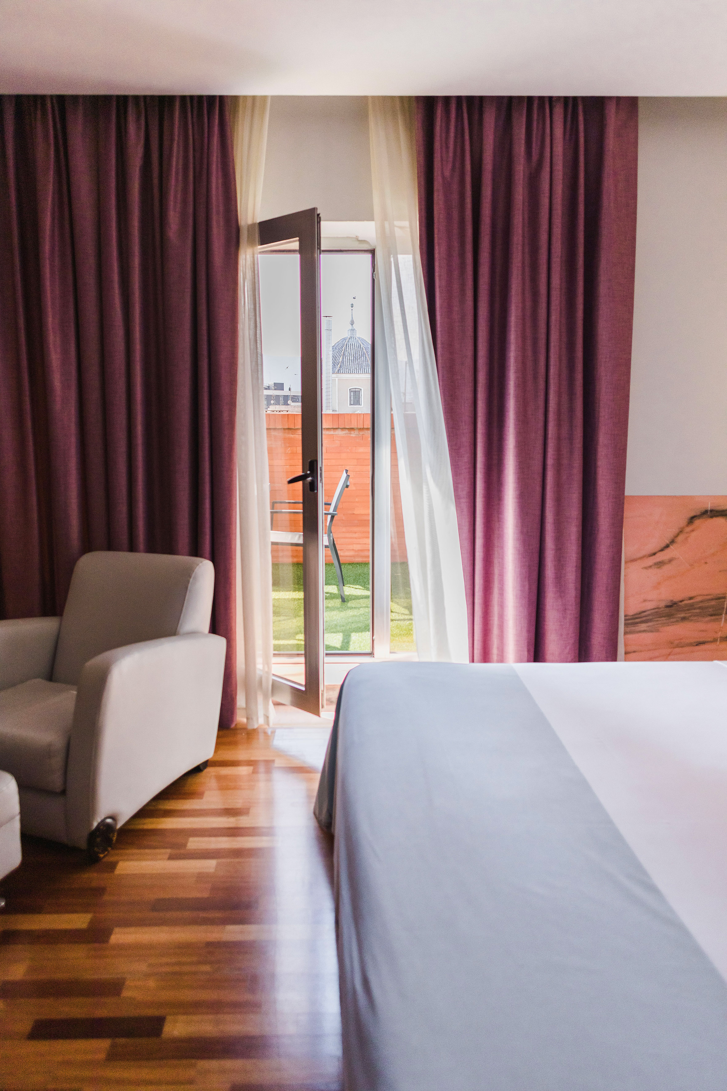 a bedroom with a bed and chairs and a door