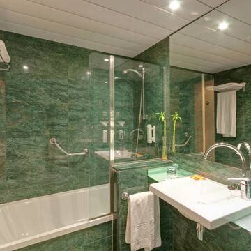 a bathroom with green marble walls and a sink and shower