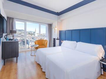 a room with two beds and a chair and a table