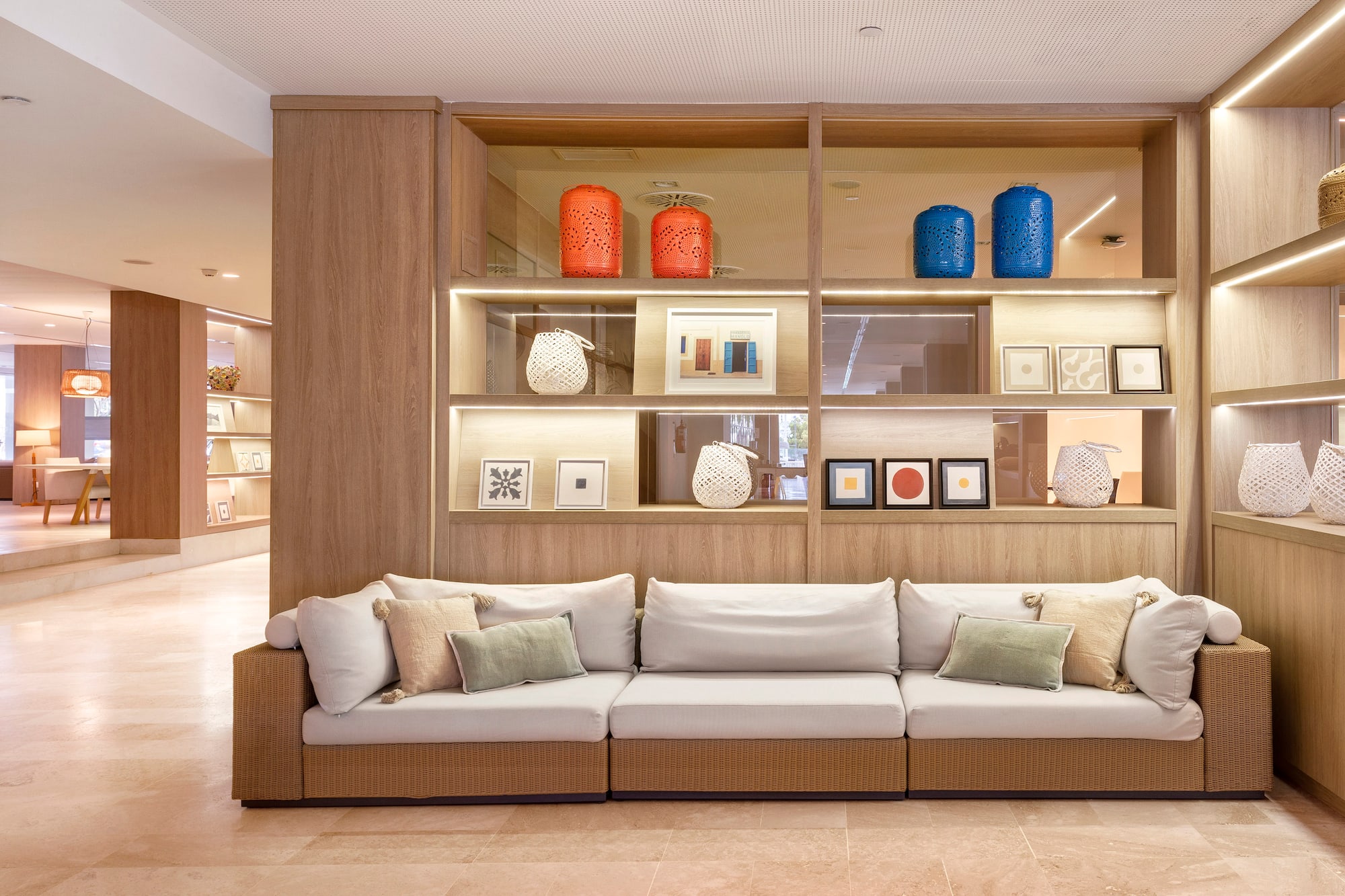 Modern lounge with modular sofa and illuminated decorative shelving.