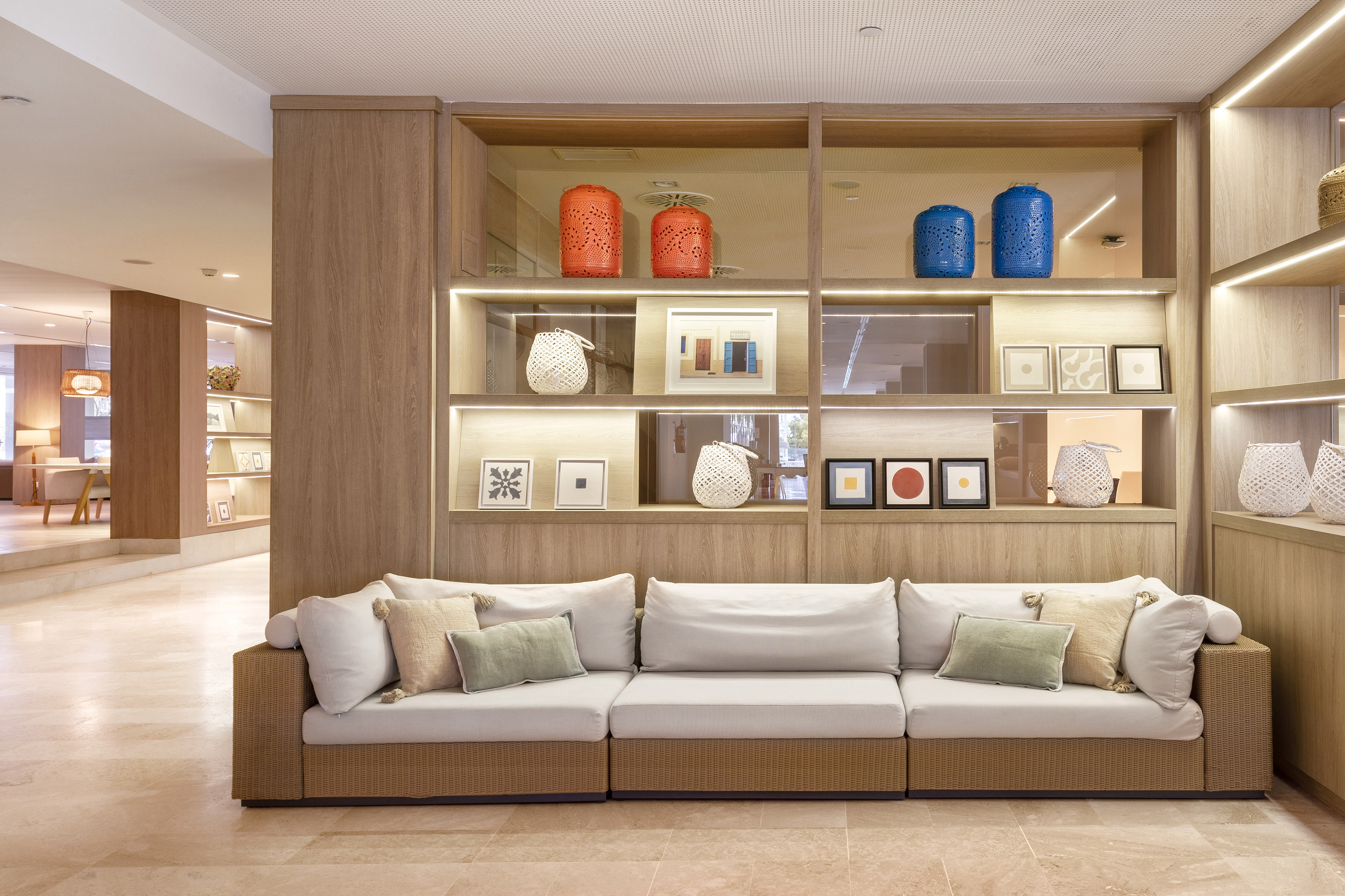 Modern lounge with modular sofa and illuminated decorative shelving.