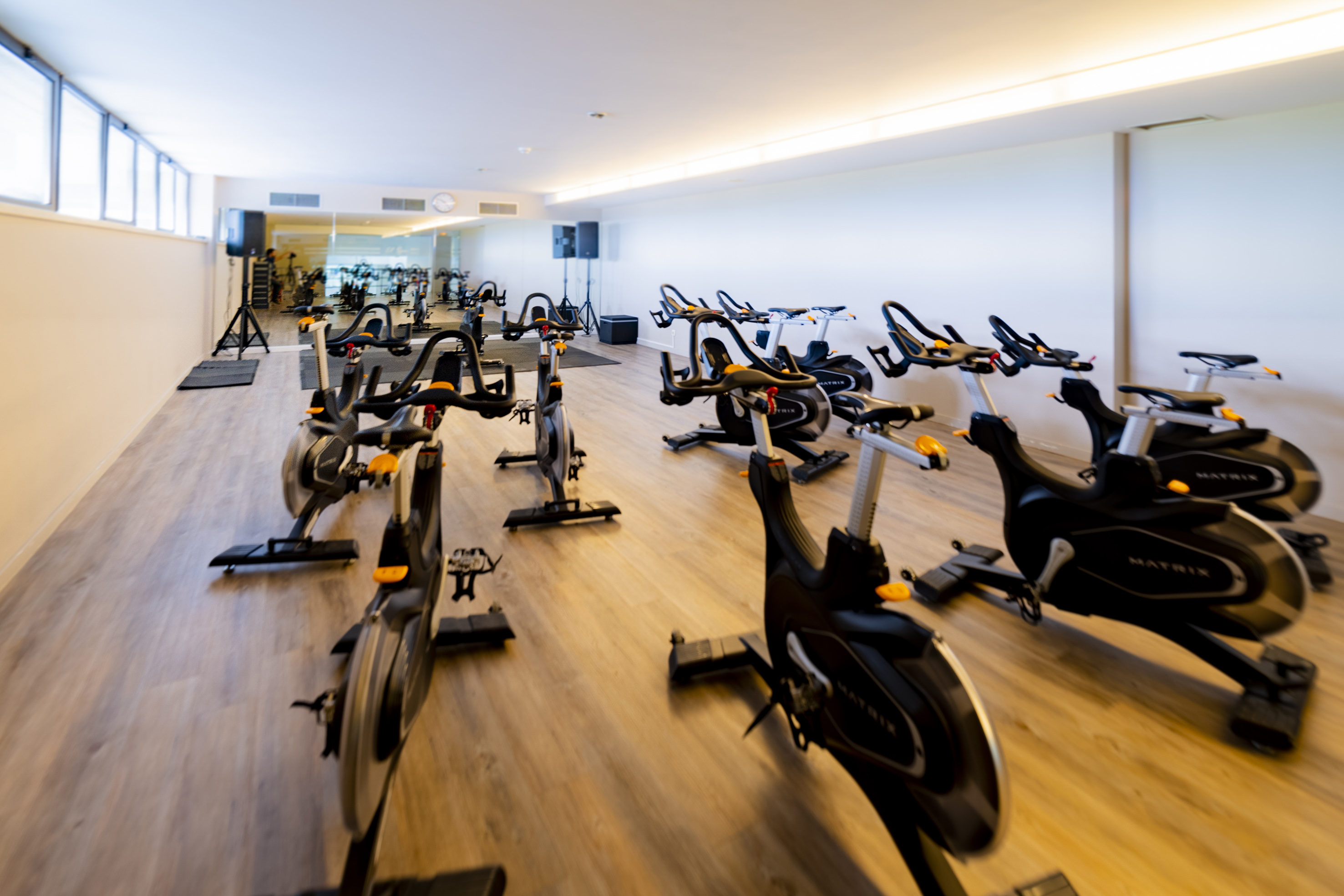 Empty modern gym spin studio with rows of Matrix exercise bikes.