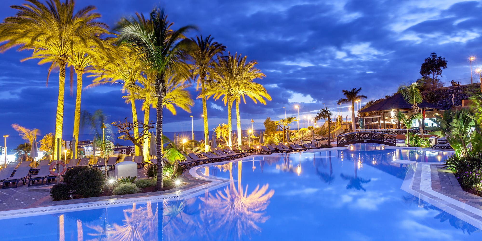 a pool with palm trees and buildings
