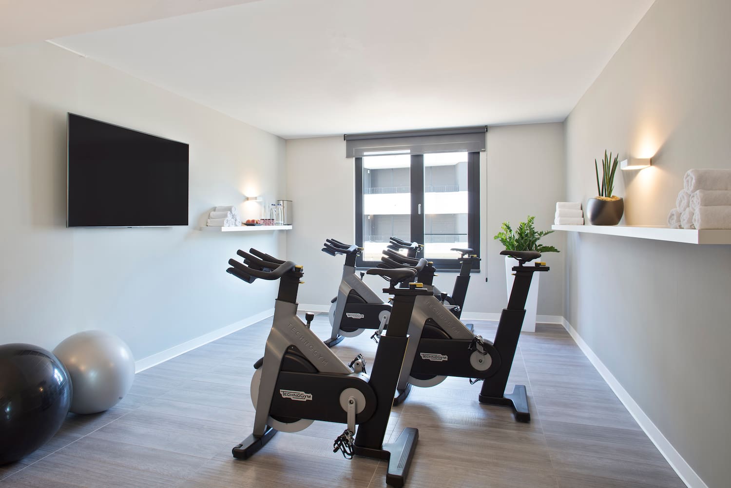 a room with exercise bikes and a tv