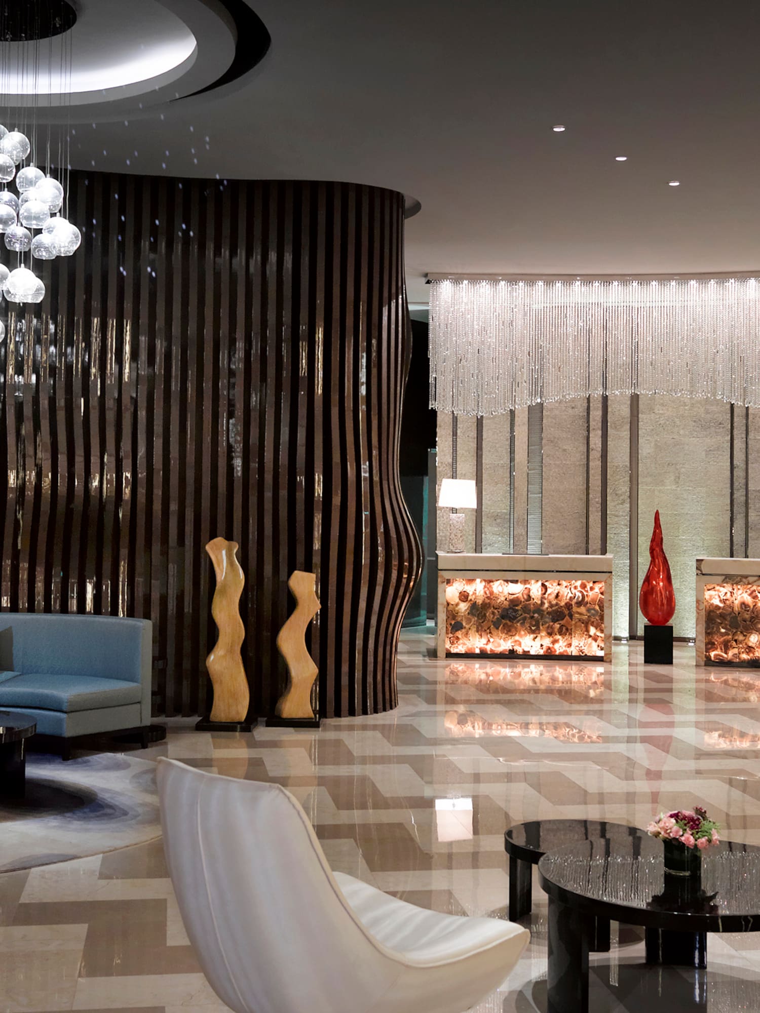 a lobby with a chandelier and chairs