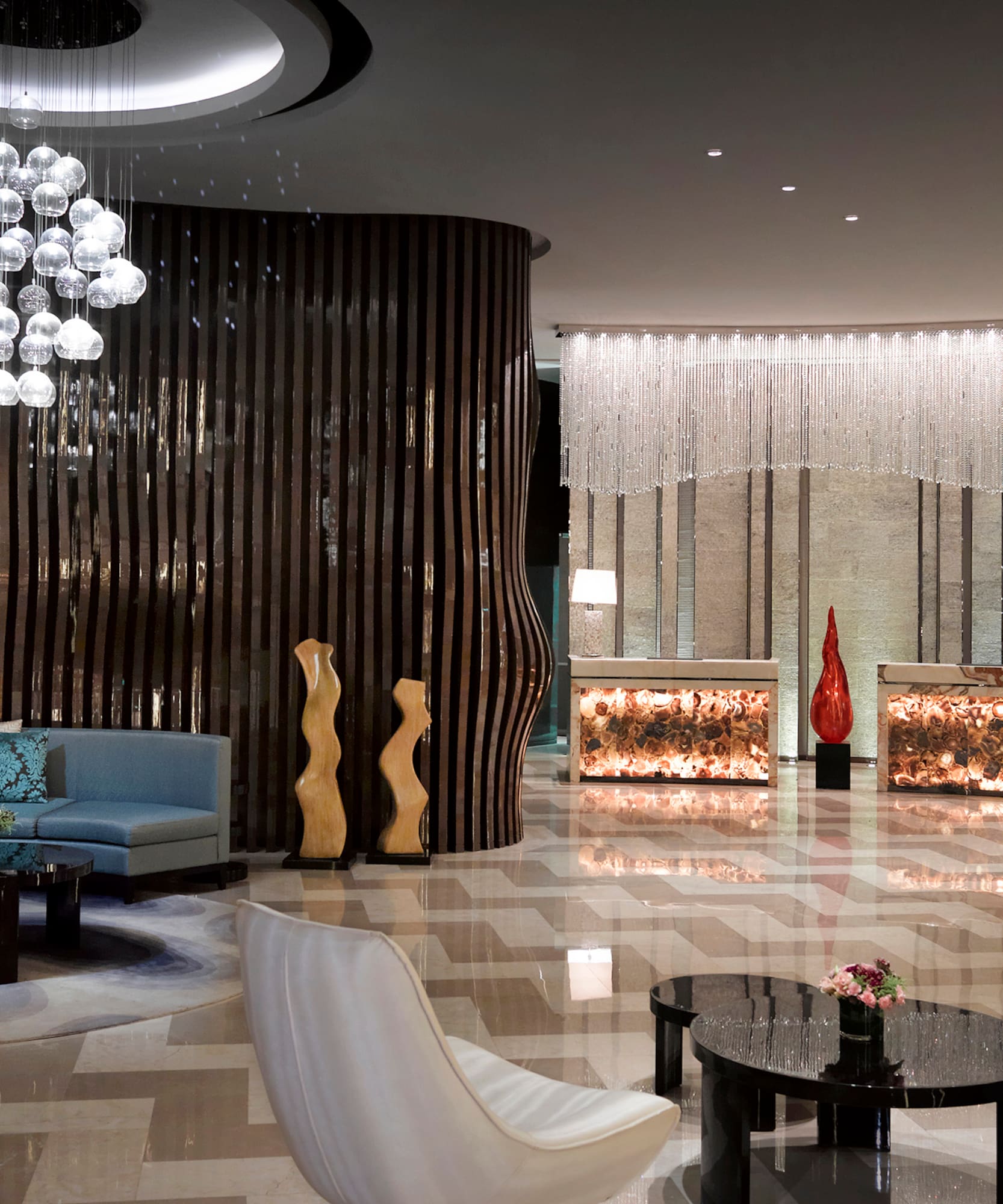 a lobby with a chandelier and chairs