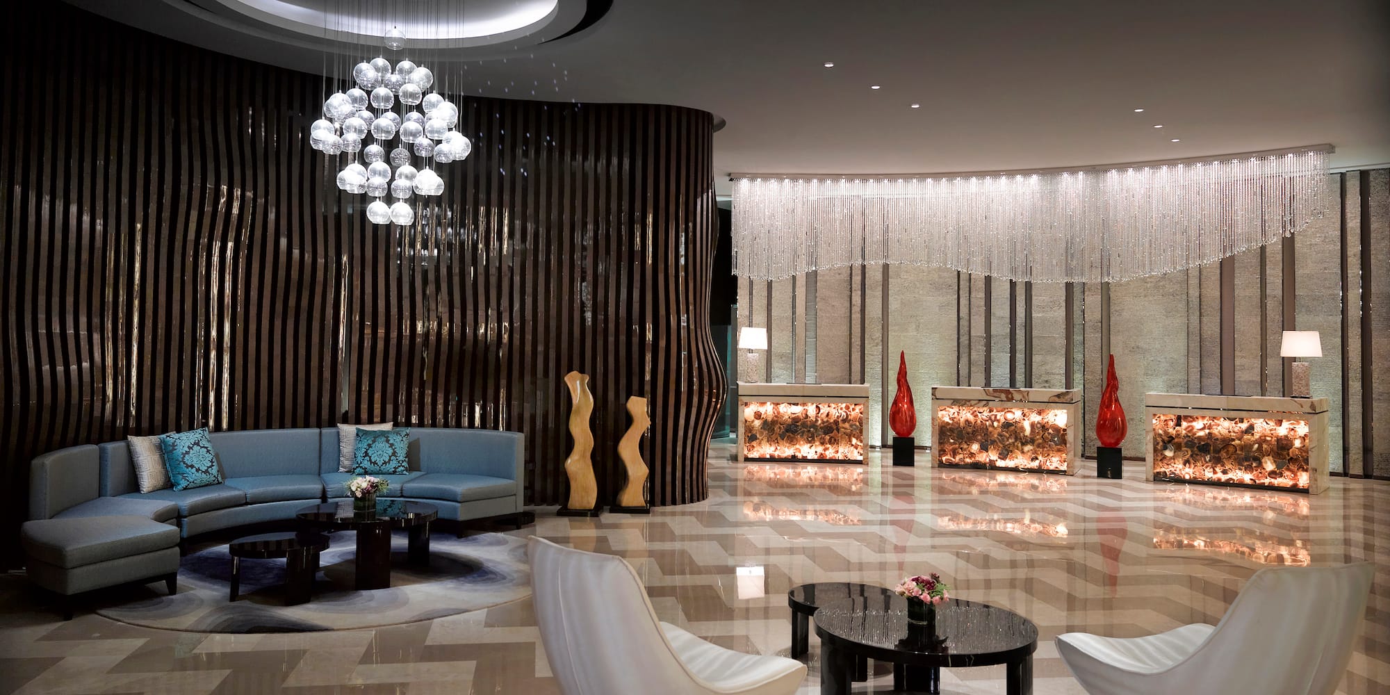 a lobby with a chandelier and chairs