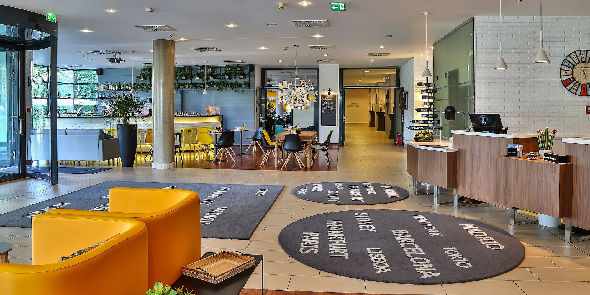 a room with a yellow couch and a black rug