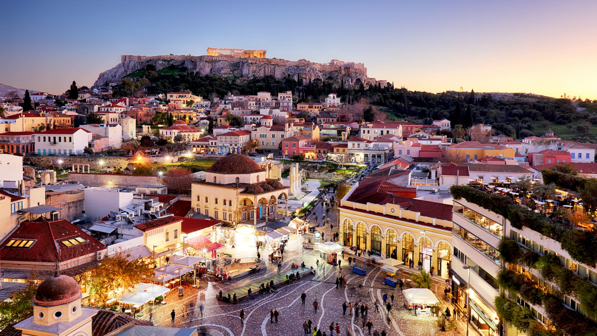 a city with buildings and a hill in the background