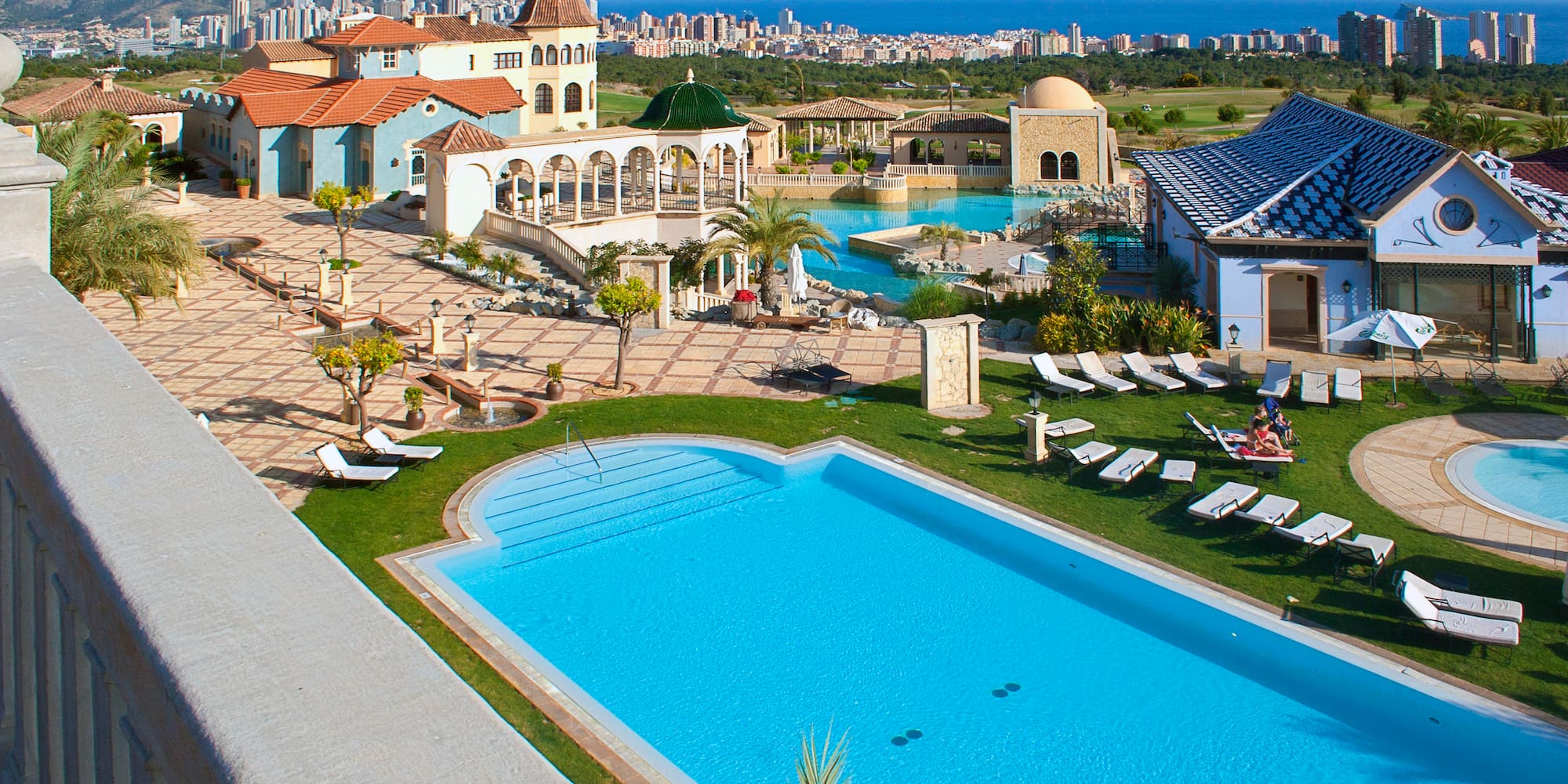 a pool and a building with a city in the background
