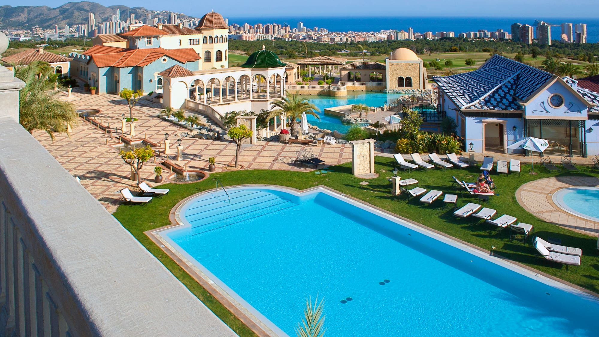 a pool and a building with a city in the background