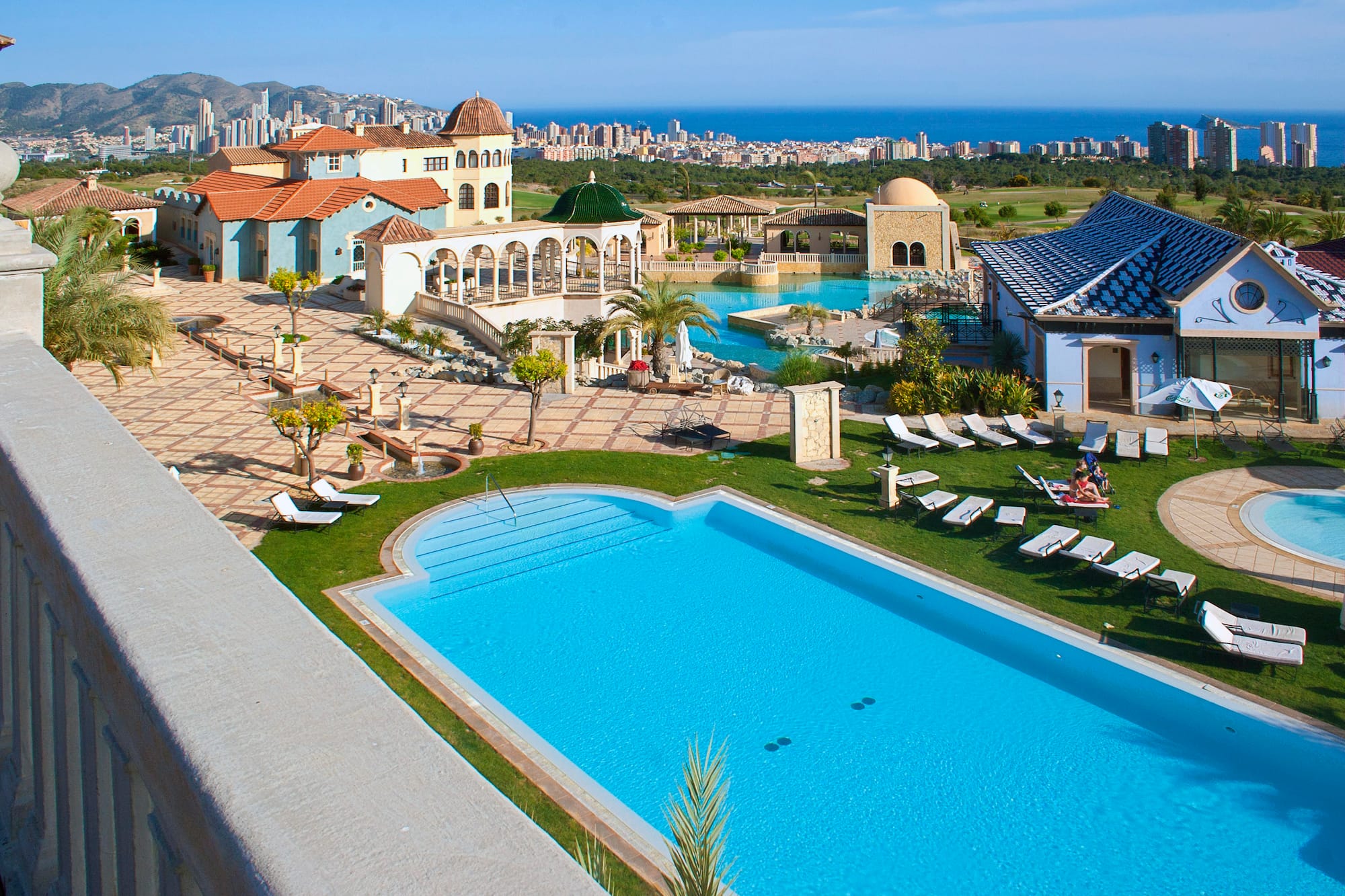 a pool and a building with a city in the background