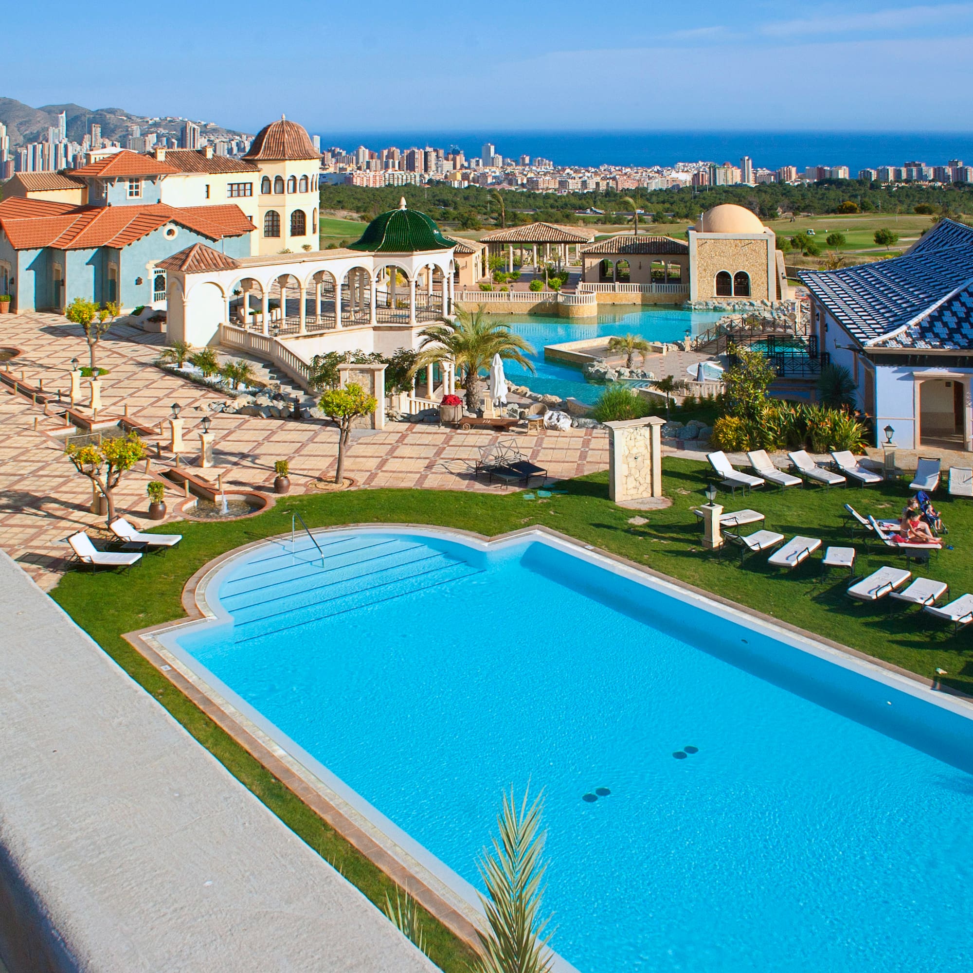 a pool and a building with a city in the background