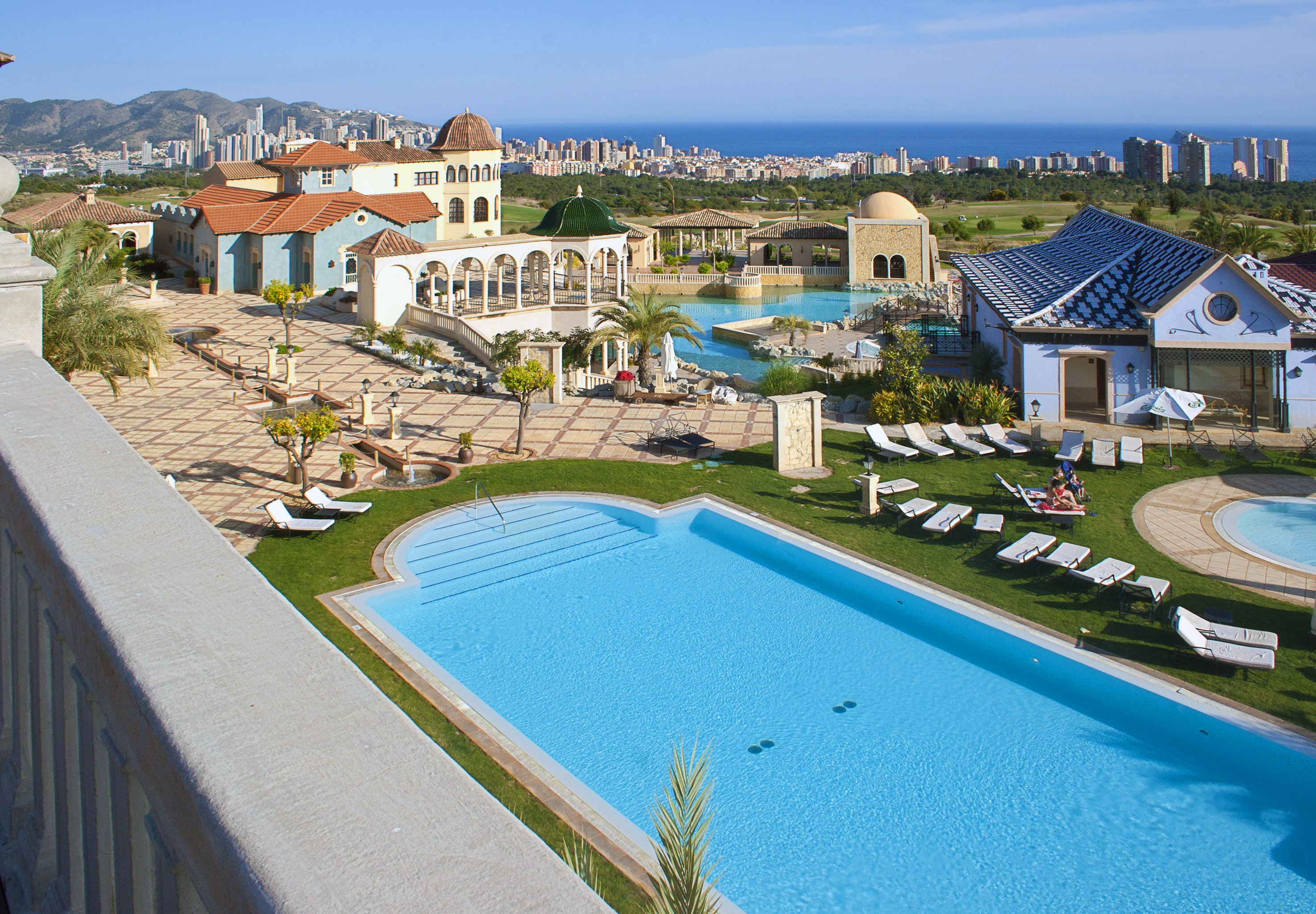 a pool and a building with a city in the background