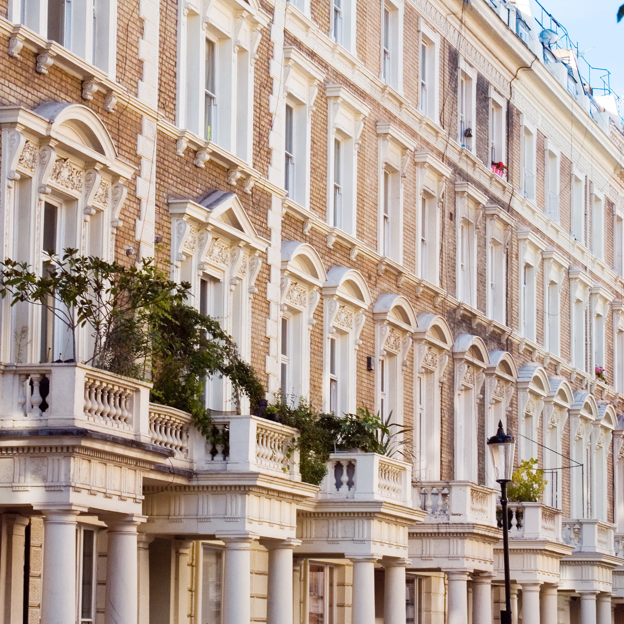 Fachadas victorianas de ladrillo con balcones ornamentados en Londres.