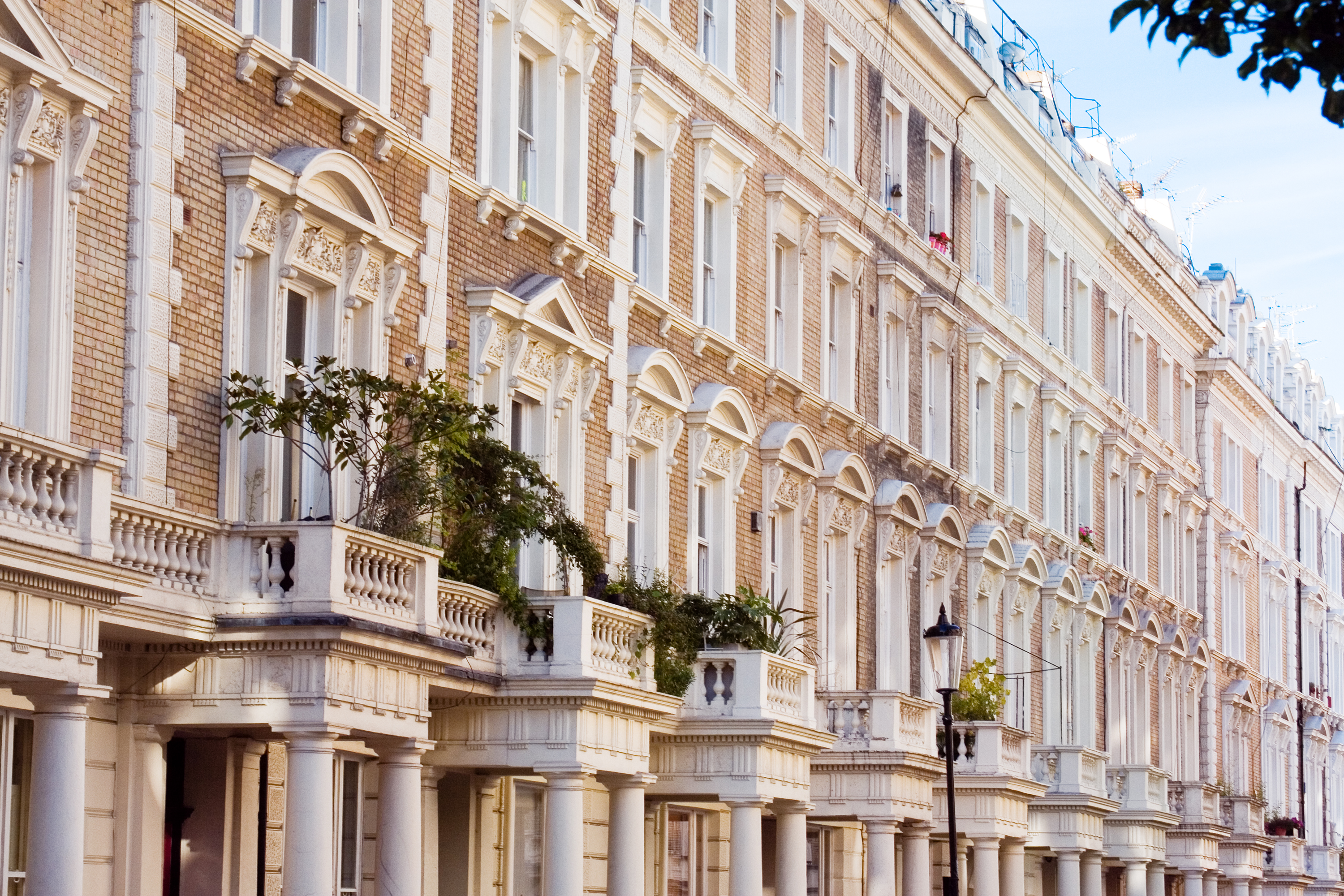 Fachadas victorianas de ladrillo con balcones ornamentados en Londres.