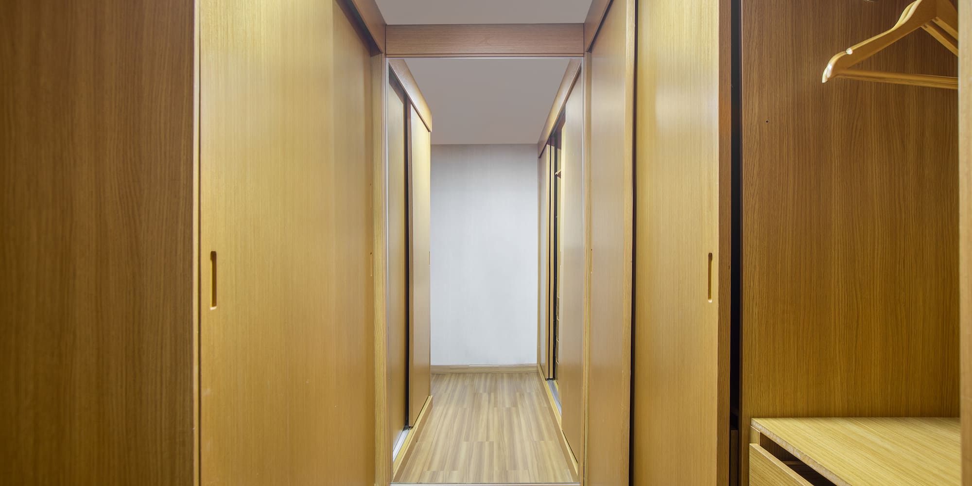 a hallway with wooden cabinets and drawers
