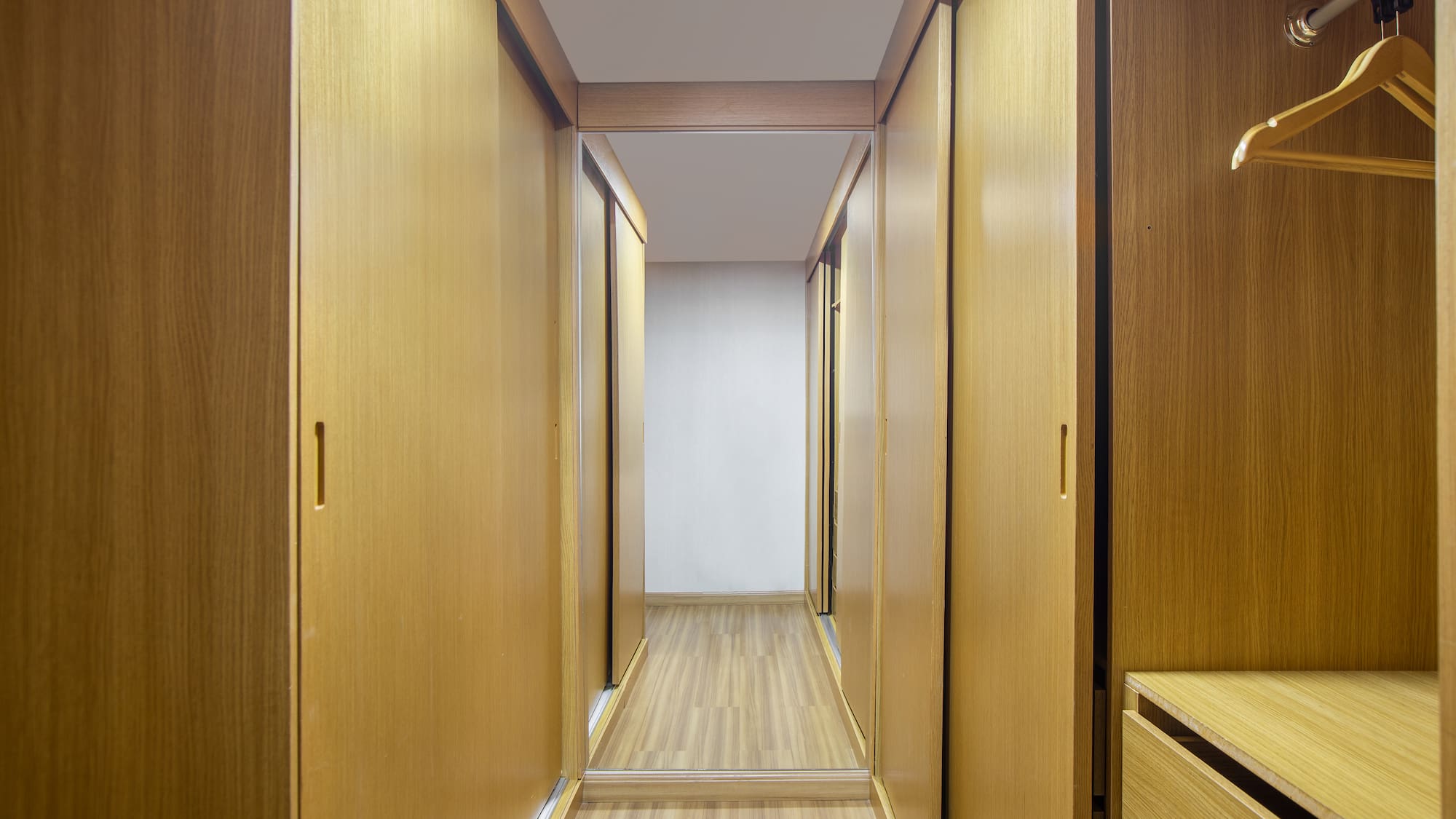 a hallway with wooden cabinets and drawers