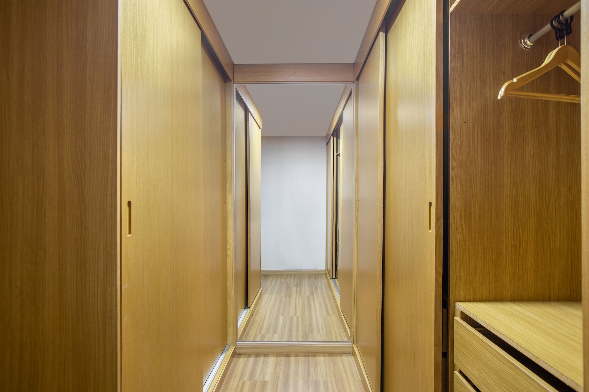 a hallway with wooden cabinets and drawers