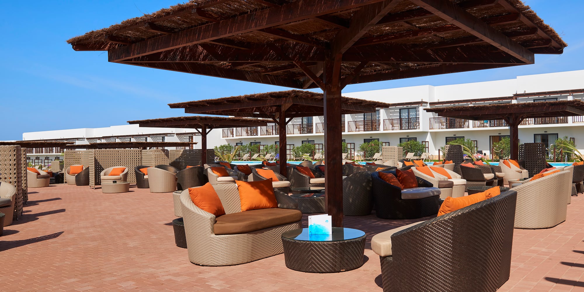 a patio with a covered area with chairs and a table