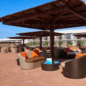 a patio with a covered area with chairs and a table