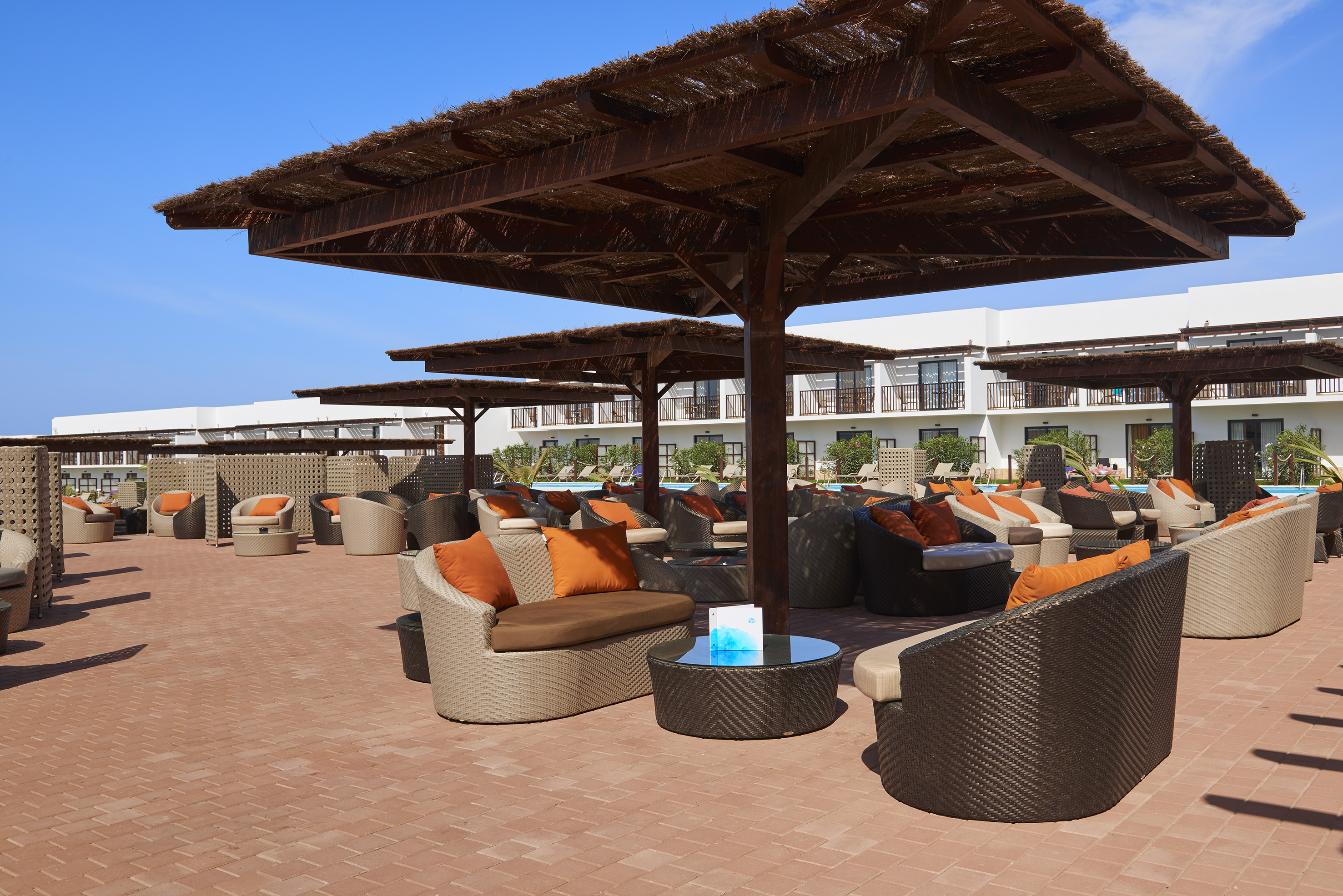 a patio with a covered area with chairs and a table