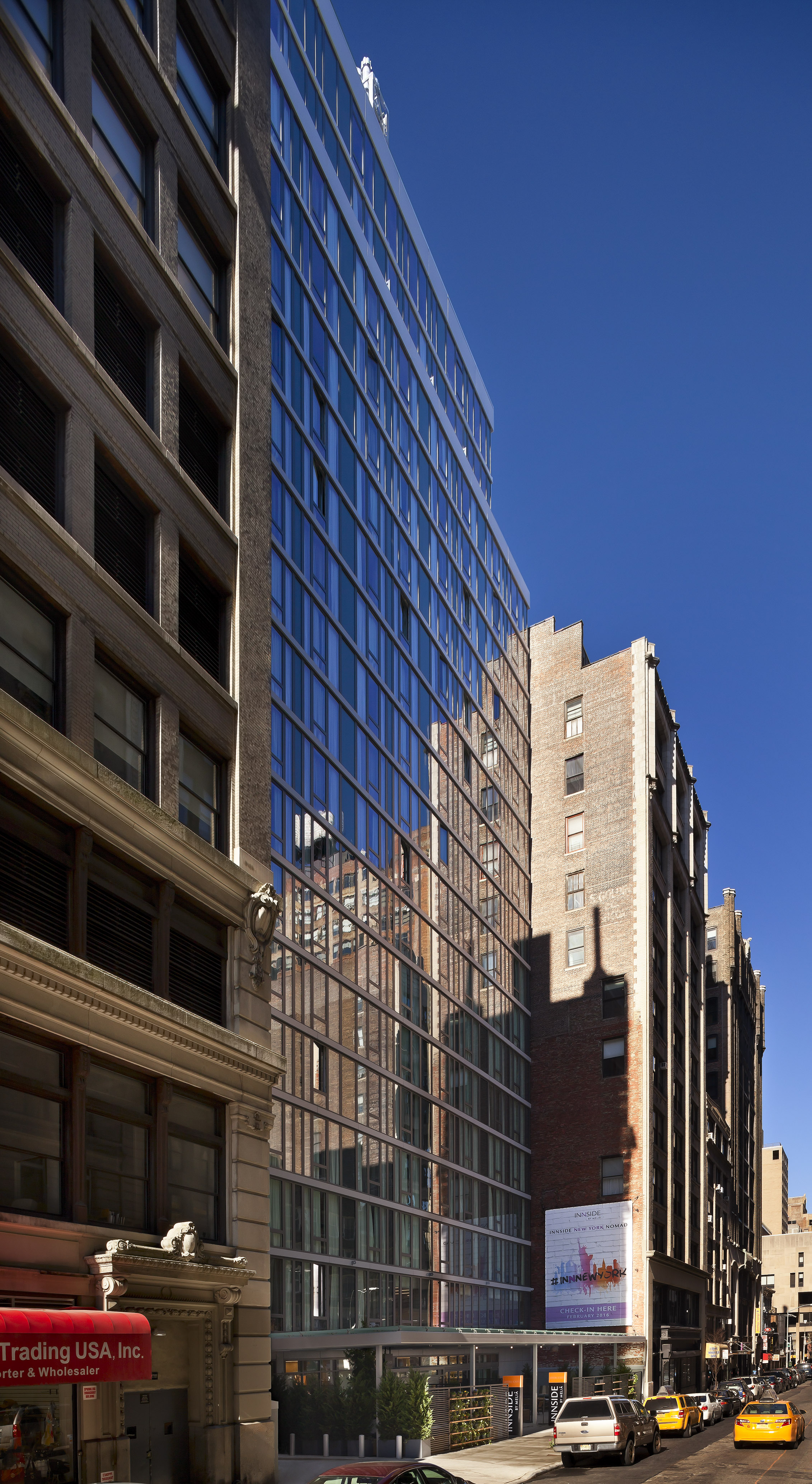 INNSIDE hotel with modern glass facade and brick buildings in NYC.