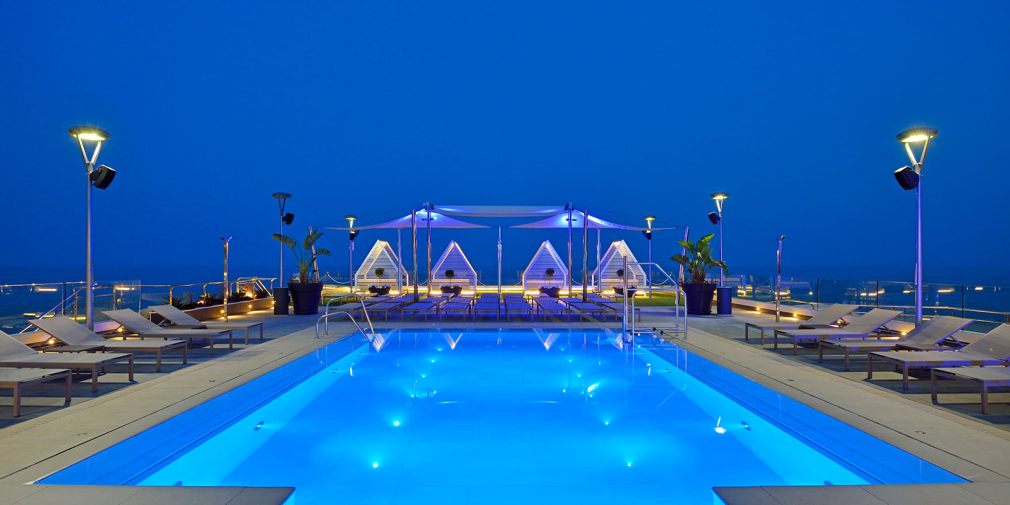 a pool with chairs and a tent on the side