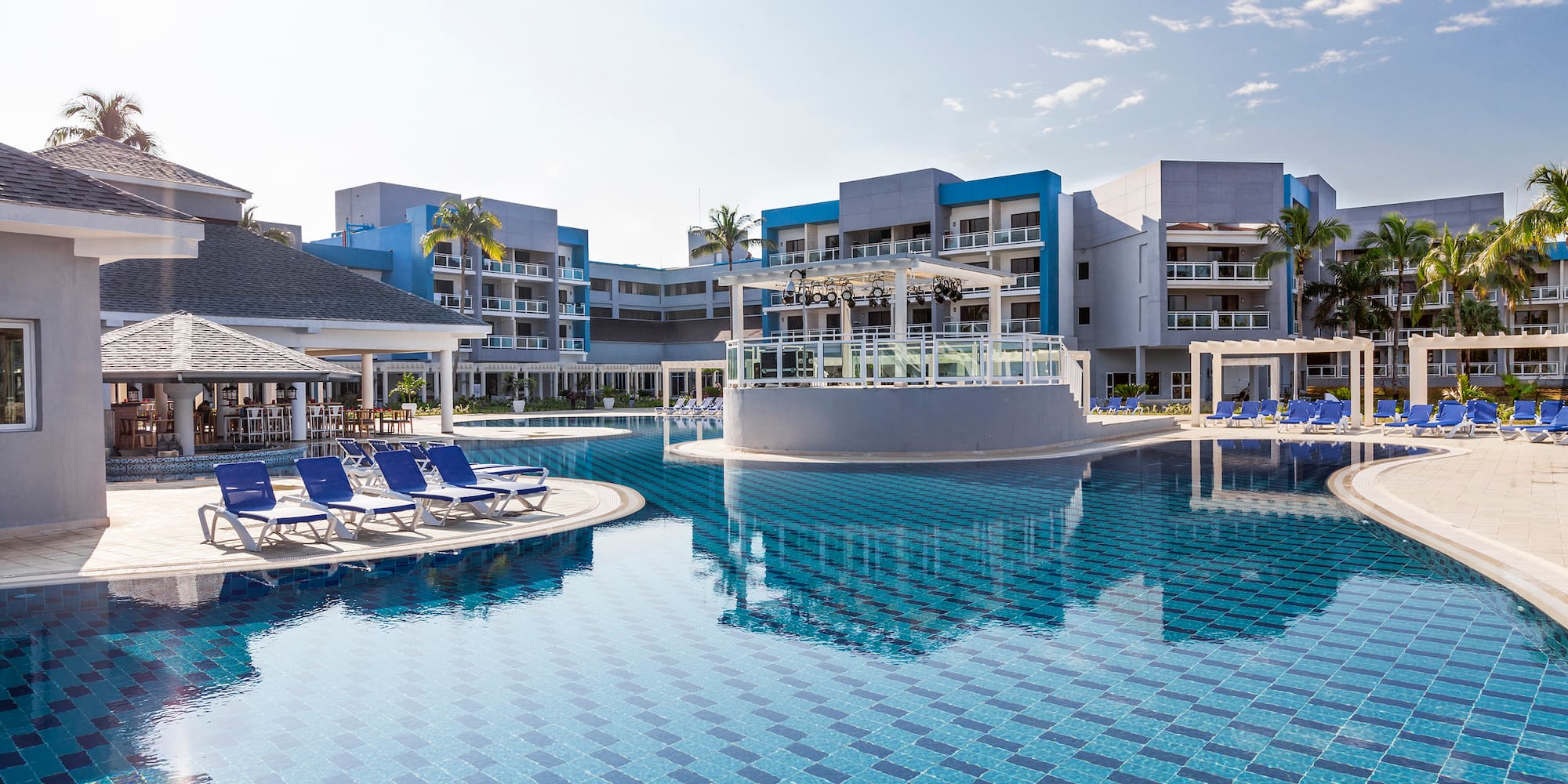 a pool with lounge chairs and a building in the background